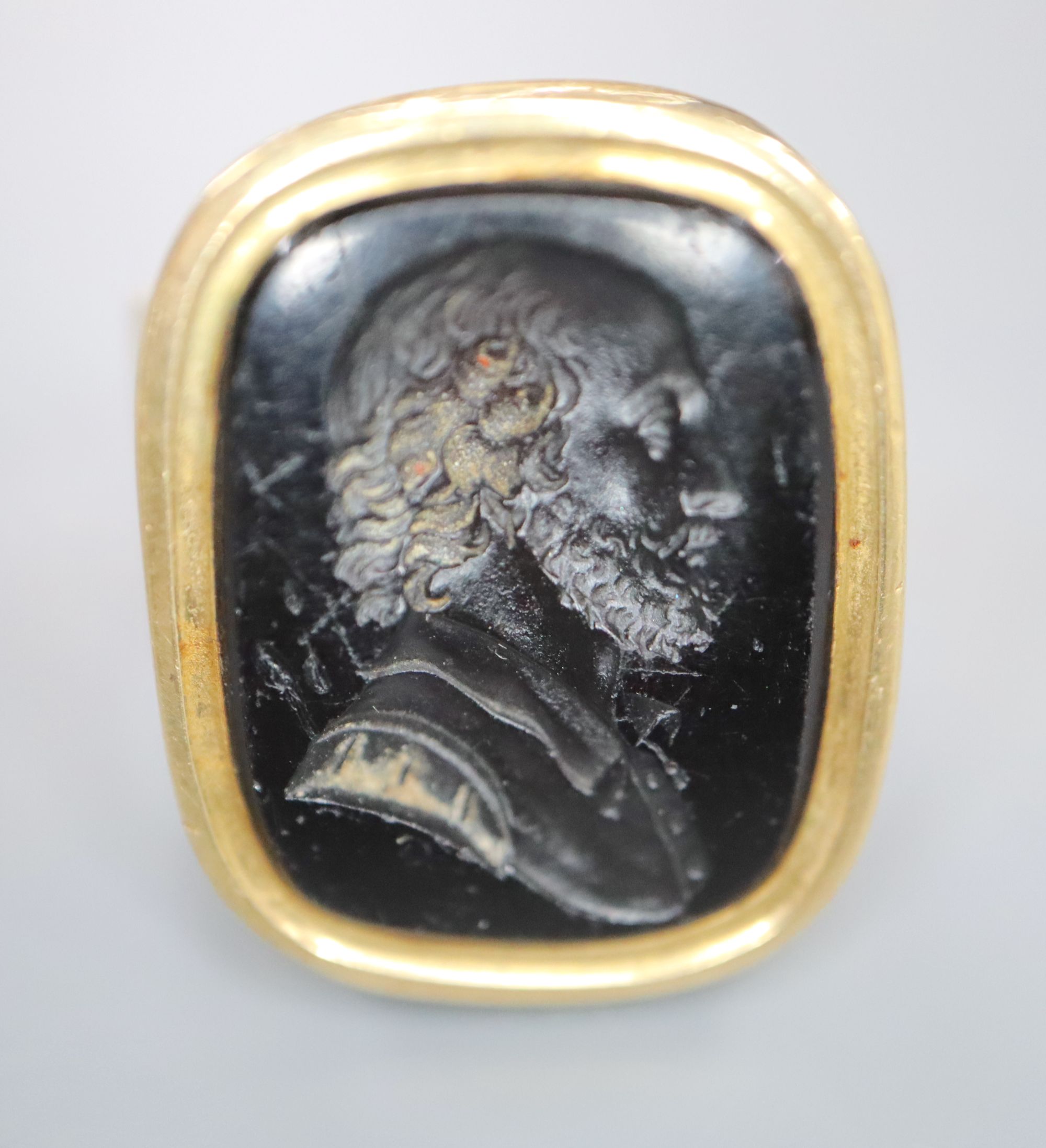 A 9ct and black onyx? intaglio ring, carved with the bust of a gentleman to sinister, size R/S, gross 16.2 grams.